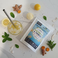 Natures Plus Electrolyte & Turmeric Complex package on a white surface with a glass of yellow liquid.