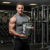 Pure Lean Nutrition Creatine Monohydrate supplement package on a surface with fitness equipment.