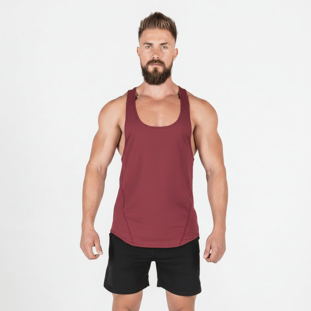 Man wearing a maroon tank top and black shorts on a white background