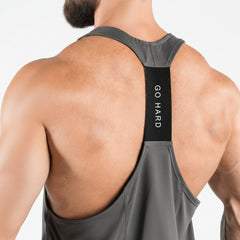 Person wearing a gray tank top with 'GO HARD' text on a white background