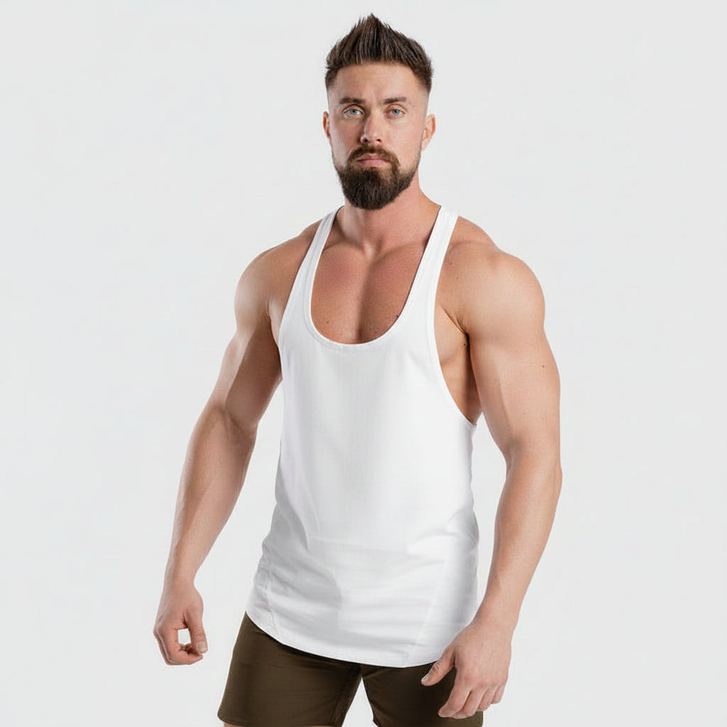 Man wearing a white tank top with visible tattoos on a plain background
