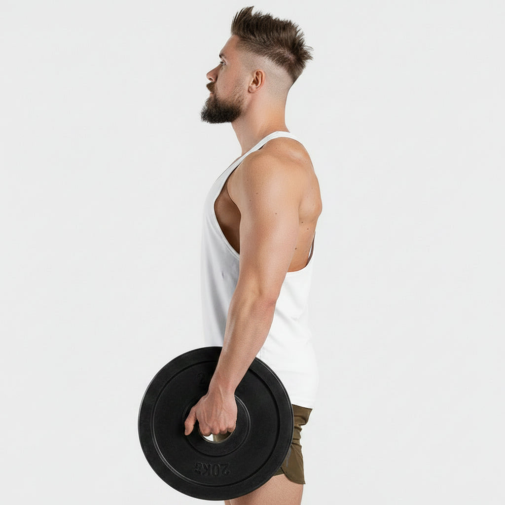 Man wearing a white tank top and green shorts on a light gray background